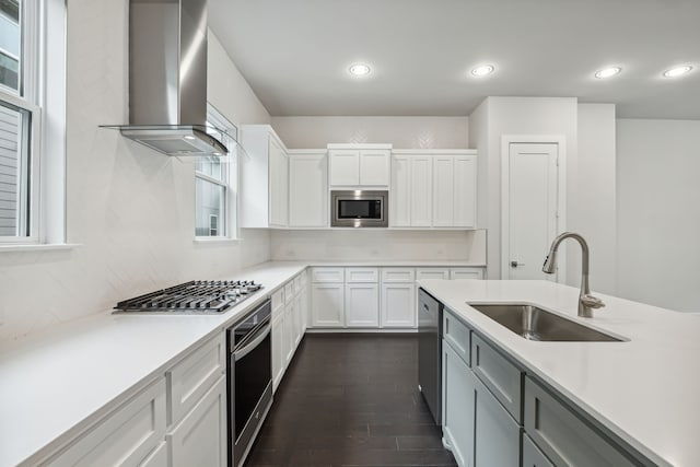 kitchen featuring a sink, light countertops, wall chimney exhaust hood, stainless steel appliances, and decorative backsplash