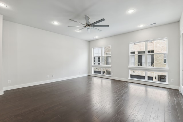 unfurnished living room with dark hardwood / wood-style floors, ceiling fan, and a healthy amount of sunlight