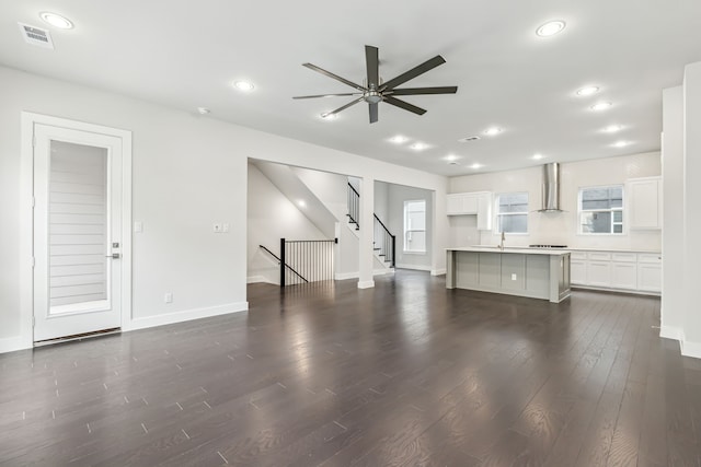 unfurnished living room with dark wood-type flooring, sink, and ceiling fan