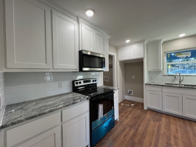 kitchen featuring decorative backsplash, dark hardwood / wood-style flooring, sink, white cabinets, and black / electric stove