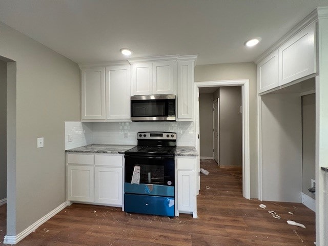 kitchen with dark hardwood / wood-style flooring, range with electric cooktop, white cabinetry, and backsplash