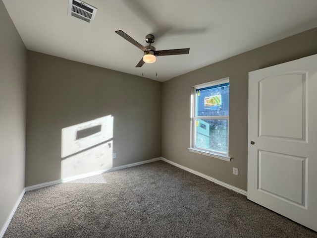 carpeted spare room featuring ceiling fan