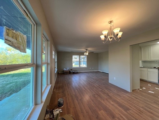 unfurnished living room with dark hardwood / wood-style flooring and ceiling fan with notable chandelier