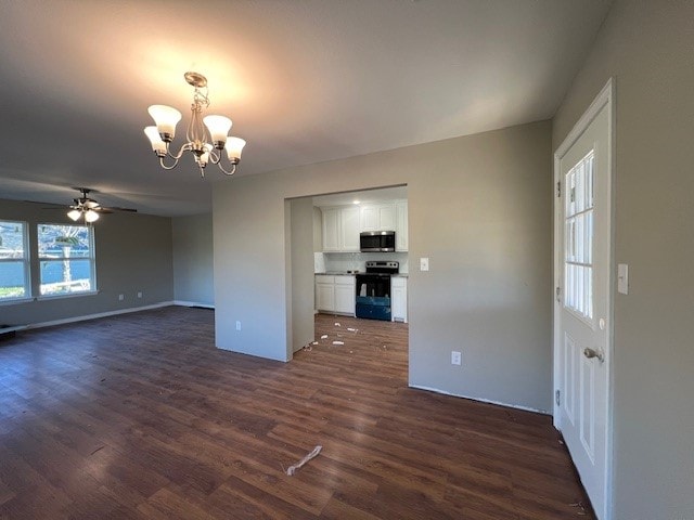 unfurnished living room featuring ceiling fan with notable chandelier and dark hardwood / wood-style flooring