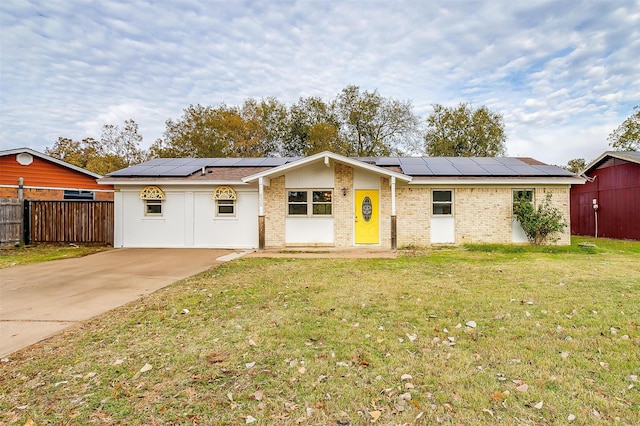 ranch-style home with a front lawn and solar panels