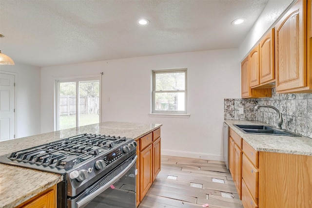 kitchen with light hardwood / wood-style floors, sink, a healthy amount of sunlight, and appliances with stainless steel finishes