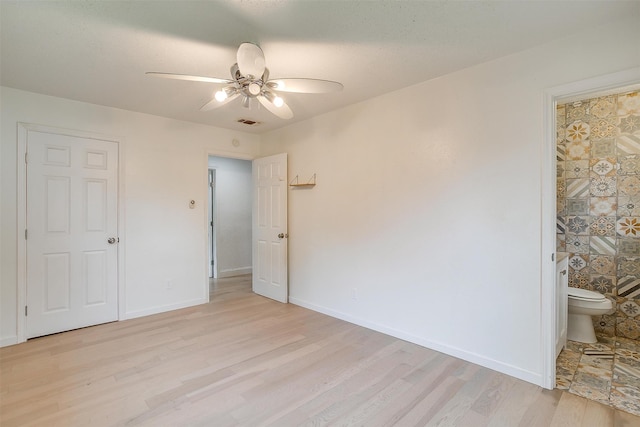 unfurnished bedroom featuring connected bathroom, ceiling fan, and light hardwood / wood-style floors