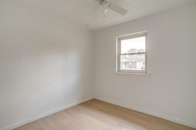 spare room featuring ceiling fan, light hardwood / wood-style flooring, and a textured ceiling