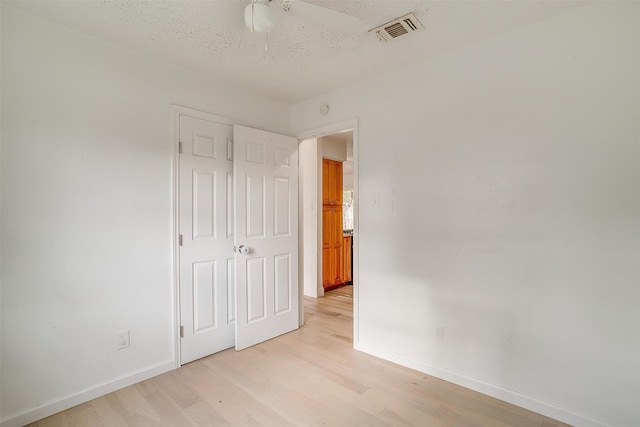 interior space featuring ceiling fan, a textured ceiling, and light wood-type flooring