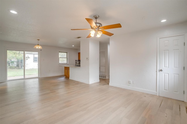 unfurnished living room featuring ceiling fan and light hardwood / wood-style flooring