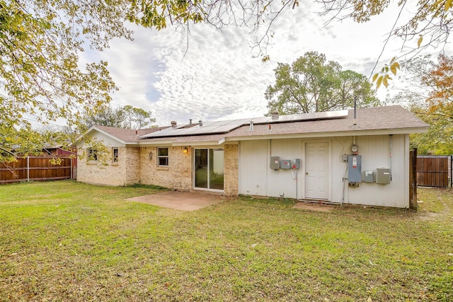 rear view of house featuring a lawn and a patio