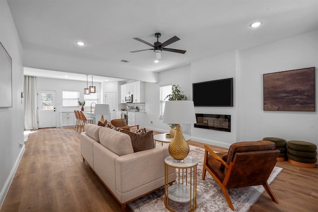 living room featuring wood-type flooring and ceiling fan