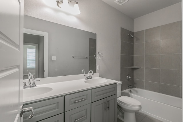 full bathroom featuring tile patterned flooring, vanity, toilet, and tiled shower / bath