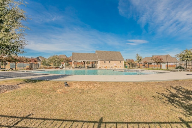 view of swimming pool with a lawn