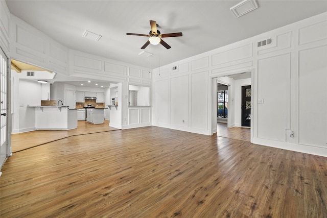 unfurnished living room with ceiling fan and wood-type flooring