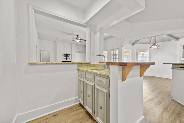 kitchen with ceiling fan, sink, light hardwood / wood-style flooring, kitchen peninsula, and decorative light fixtures