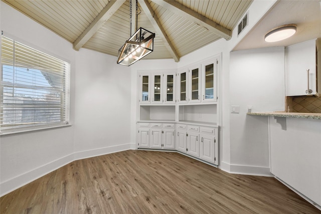 unfurnished dining area with lofted ceiling with beams, hardwood / wood-style flooring, and wooden ceiling