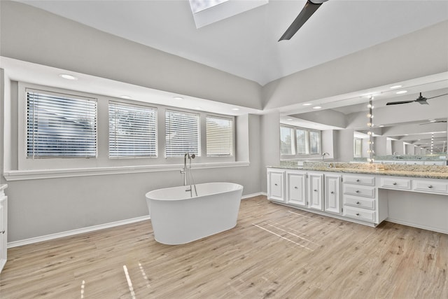 bathroom featuring vanity, ceiling fan, hardwood / wood-style floors, and a bathtub