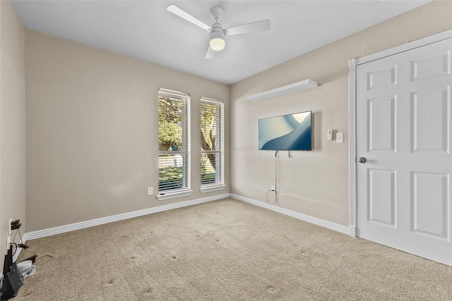 carpeted spare room featuring ceiling fan