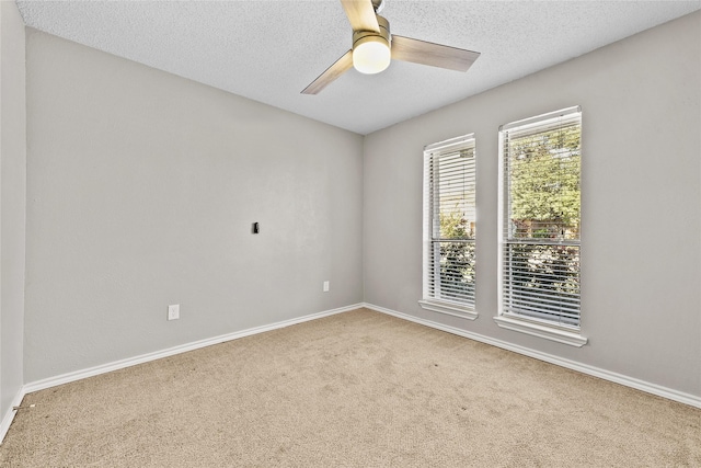 carpeted empty room featuring ceiling fan and a textured ceiling