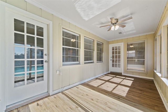 unfurnished sunroom featuring ceiling fan