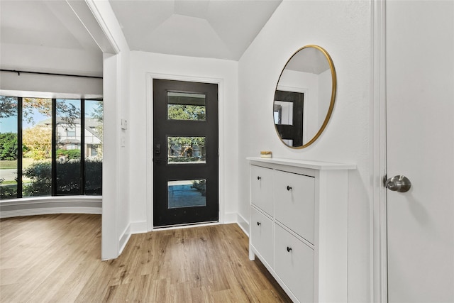 entrance foyer featuring light hardwood / wood-style floors and lofted ceiling