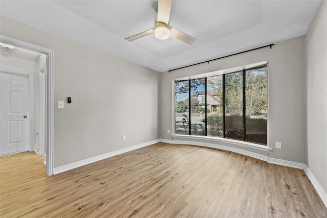 empty room with ceiling fan and light hardwood / wood-style flooring