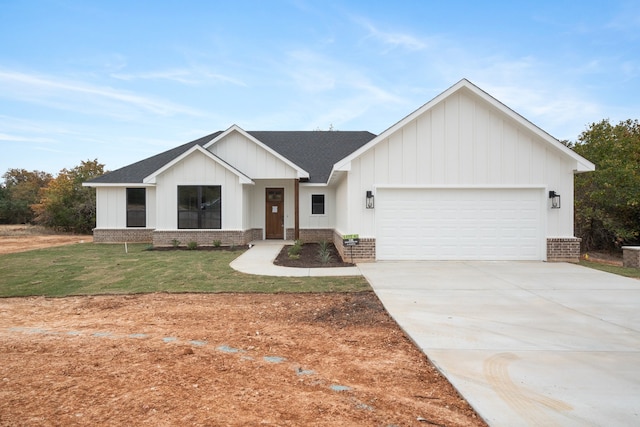 modern farmhouse featuring a garage and a front lawn