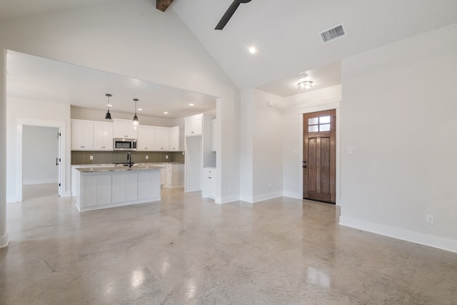 unfurnished living room featuring ceiling fan, sink, and high vaulted ceiling