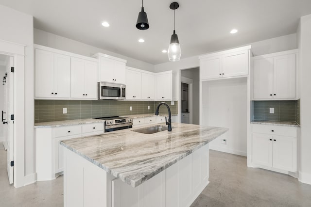 kitchen with sink, an island with sink, decorative light fixtures, and appliances with stainless steel finishes