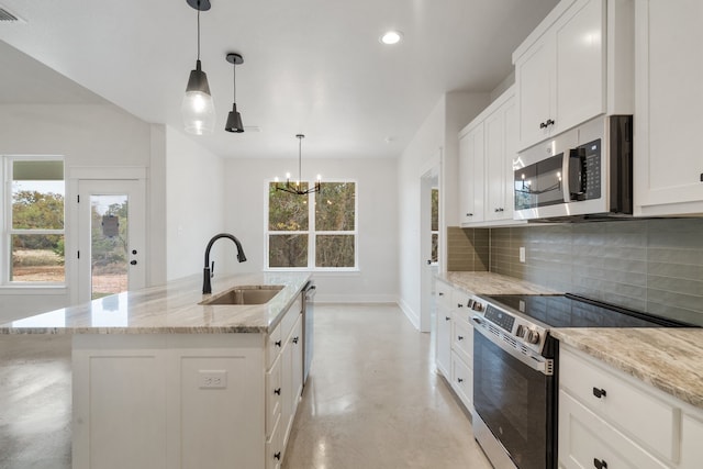 kitchen featuring a healthy amount of sunlight, sink, an island with sink, and appliances with stainless steel finishes