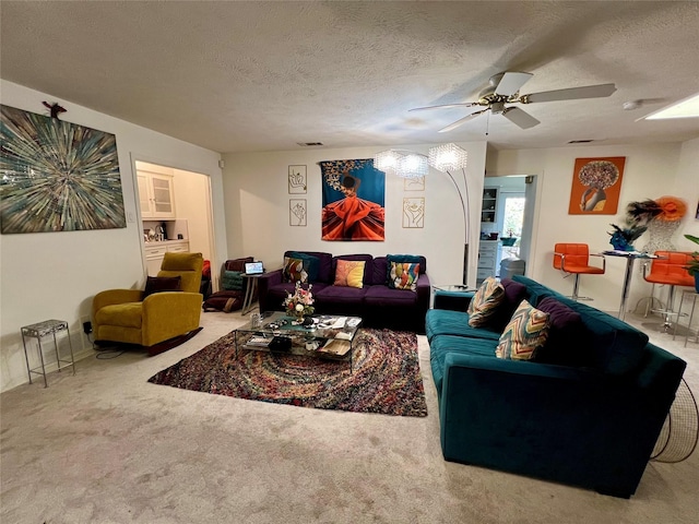 carpeted living room featuring ceiling fan and a textured ceiling