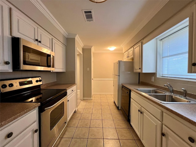 kitchen featuring appliances with stainless steel finishes, white cabinetry, sink, light tile patterned floors, and crown molding