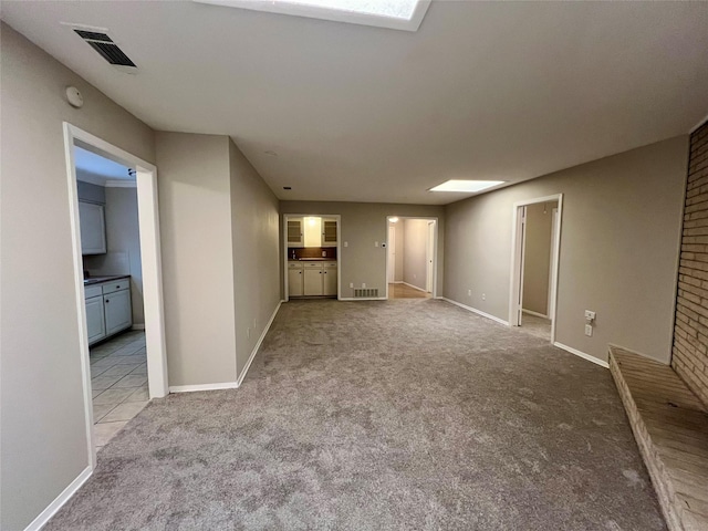 spare room with light colored carpet and a skylight