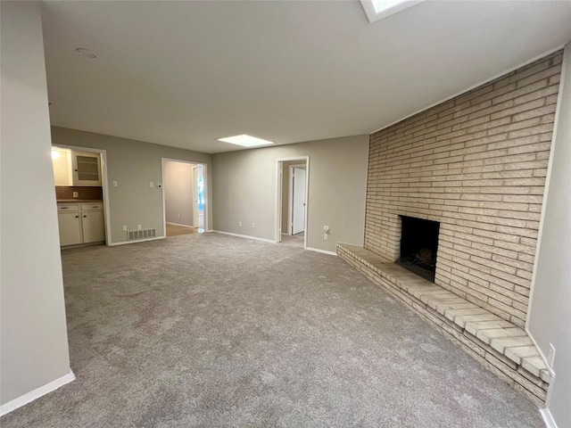 unfurnished living room featuring a fireplace and light carpet