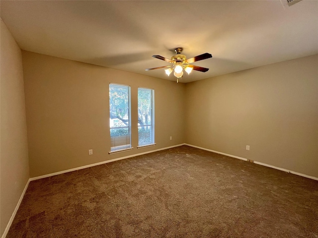 spare room featuring ceiling fan and dark carpet