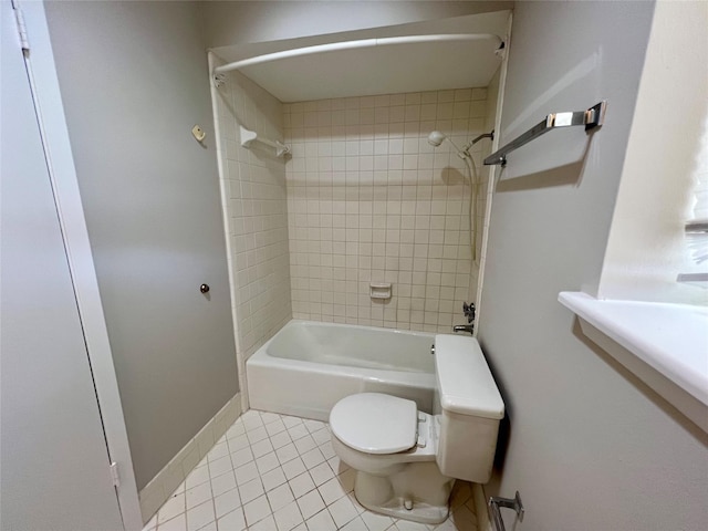 bathroom featuring tile patterned flooring, tiled shower / bath, and toilet