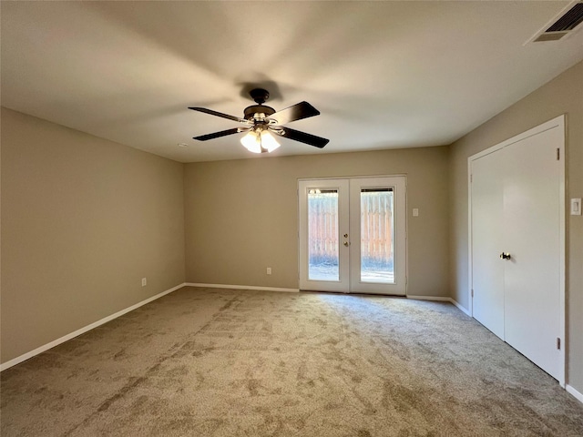 carpeted empty room with french doors and ceiling fan