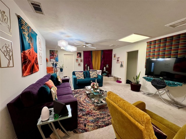 living room with ceiling fan, carpet floors, and a textured ceiling