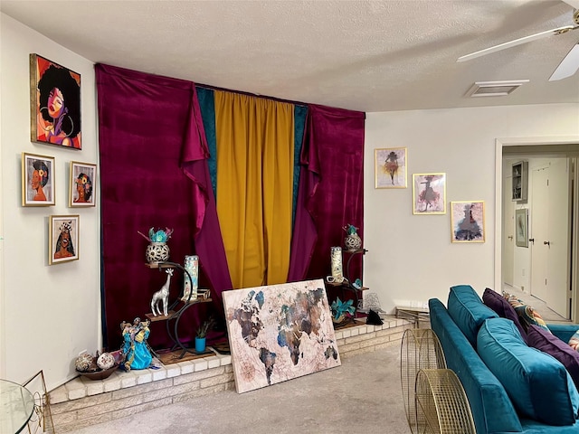 carpeted living room with ceiling fan and a textured ceiling