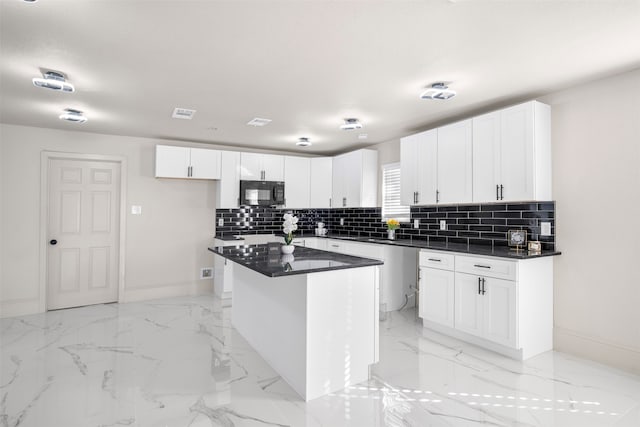 kitchen featuring decorative backsplash, a kitchen island, and white cabinetry