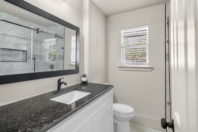 bathroom with a shower with door, vanity, and toilet