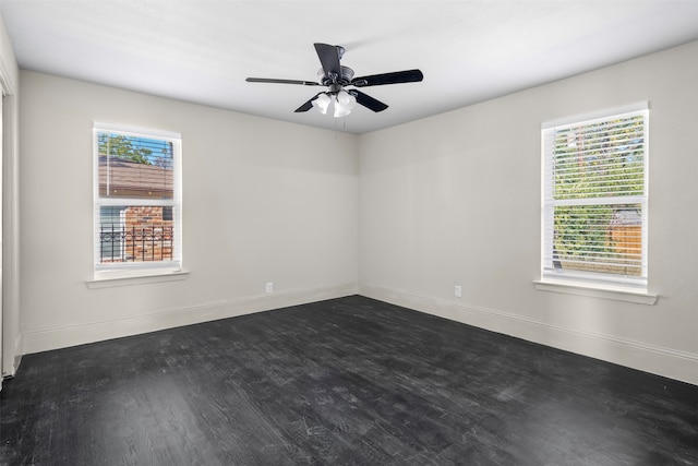 spare room with a wealth of natural light, dark hardwood / wood-style flooring, and ceiling fan