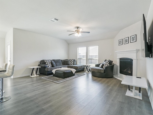 living room featuring lofted ceiling, dark wood-type flooring, and ceiling fan