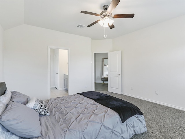 bedroom featuring lofted ceiling, light colored carpet, ceiling fan, and ensuite bath