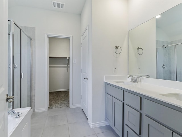 bathroom with tile patterned flooring, vanity, and walk in shower