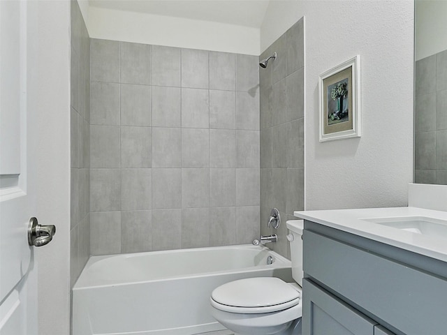 full bathroom featuring tiled shower / bath, vanity, and toilet