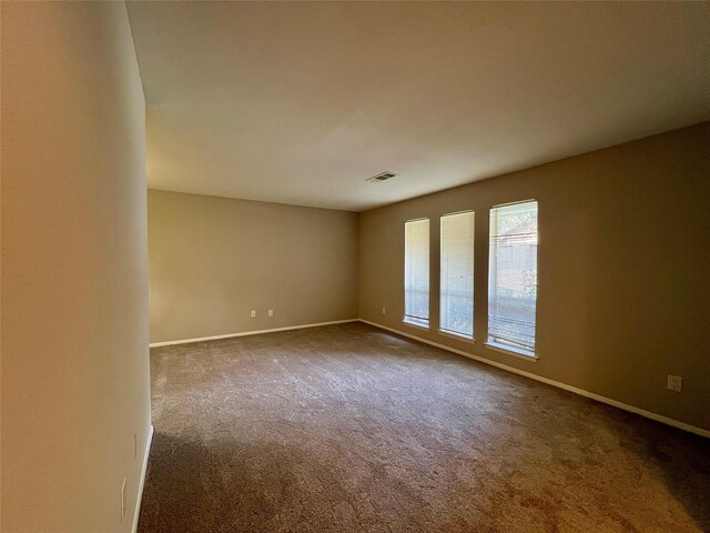 spare room featuring dark carpet