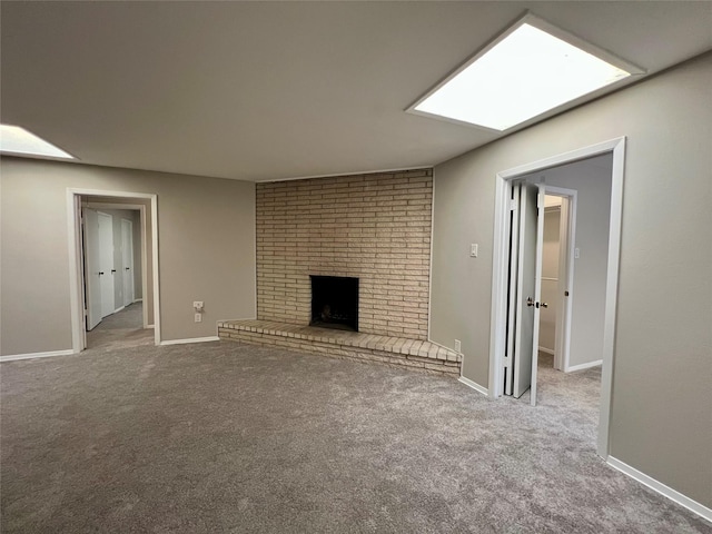 unfurnished living room with carpet and a brick fireplace