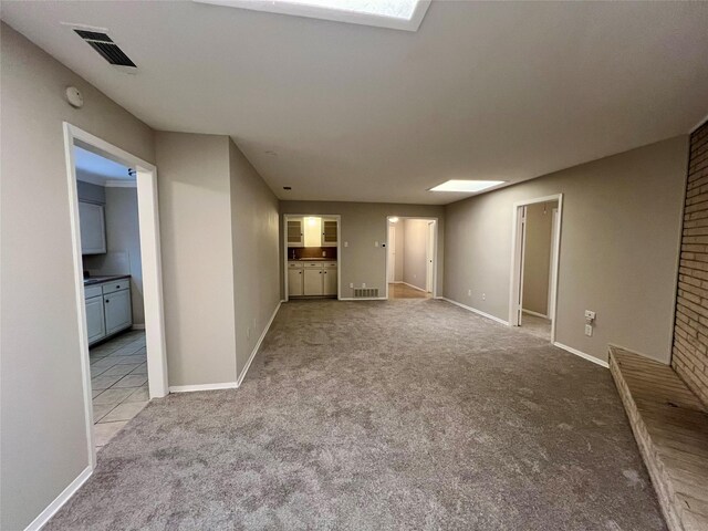 carpeted empty room featuring a skylight